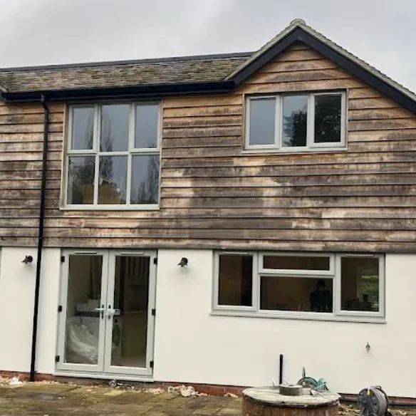 House renovation with timber cladding above rendered walls and new windows